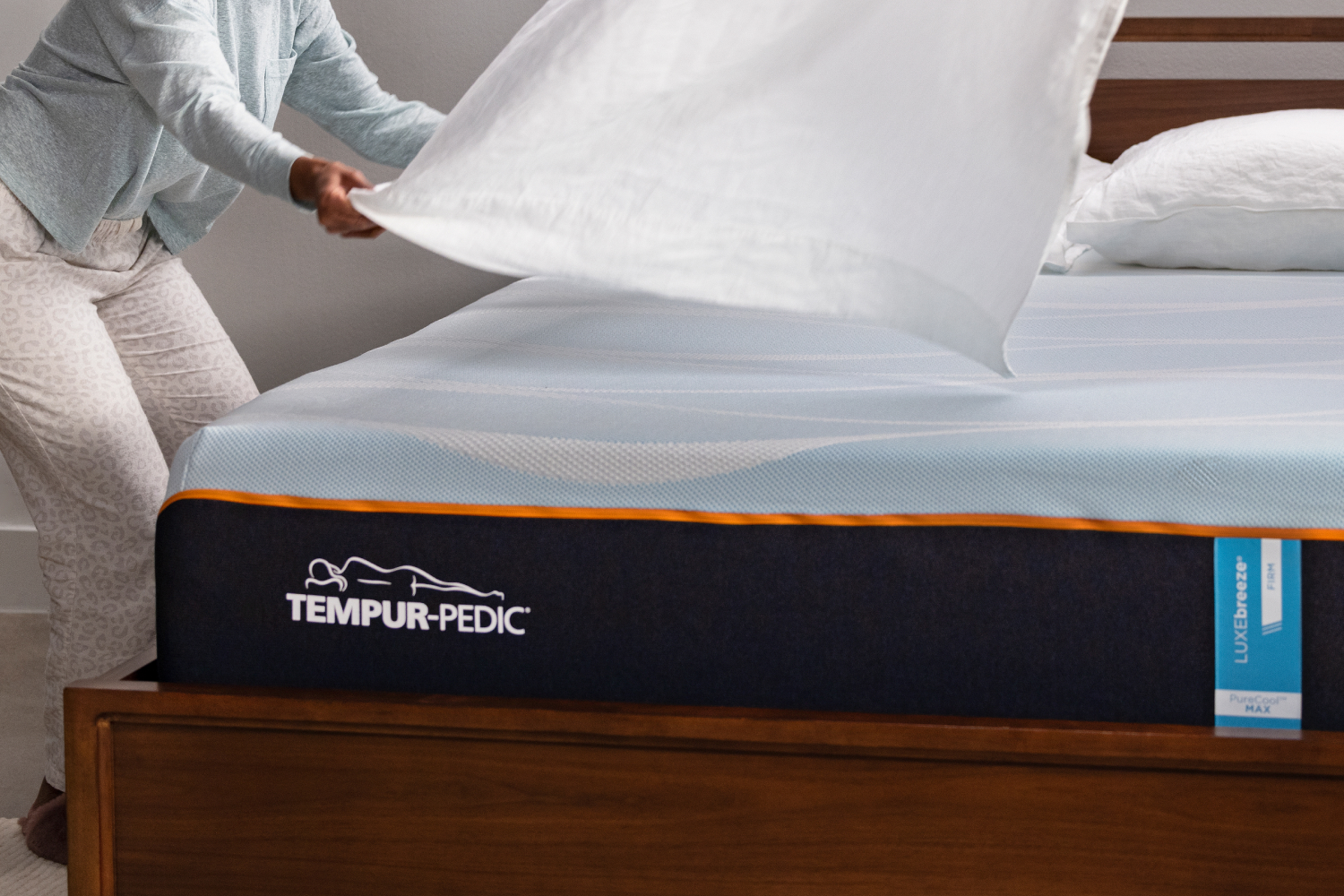 person putting sheets on a tempur-pedic luxbreeze mattress